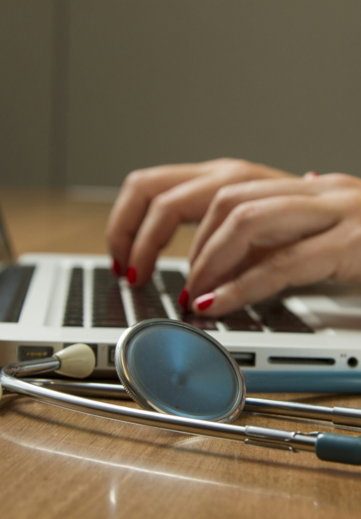 person-sitting-while-using-laptop-computer-and-green-stethoscope-near.jpg person sitting while using laptop computer and green stethoscope near